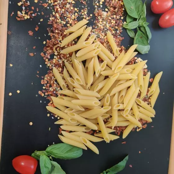 Penne crues sur une ardoise avec basilic et piment